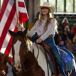 A cowgirl presenting the flag on her Paint Horse during the Cowgirl Gathering.