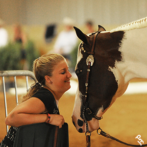 APHA member smiling while face to face with their Paint Horse.