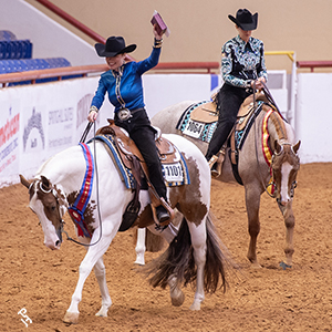 Two riders proudly display their Championship buckles as they exit the World Show arena.