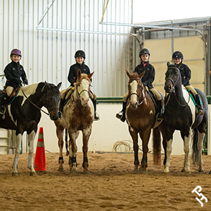 Youth riders getting ready to show their Paint Horses.