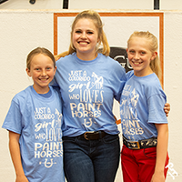 Three AjPHA members smiling in their World Show exhibitor t-shirts.