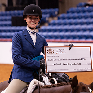 Scholarship recipient proudly displaying their check.