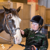 A CHAMPS exhibitor petting their horse.