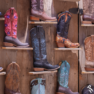 A wall full of different colored cowboy boots.