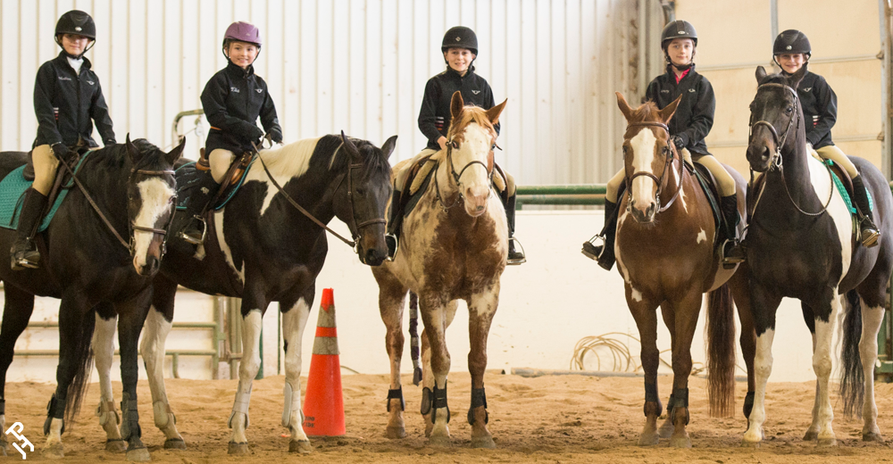 Five youth members sitting on their horses getting ready to show.